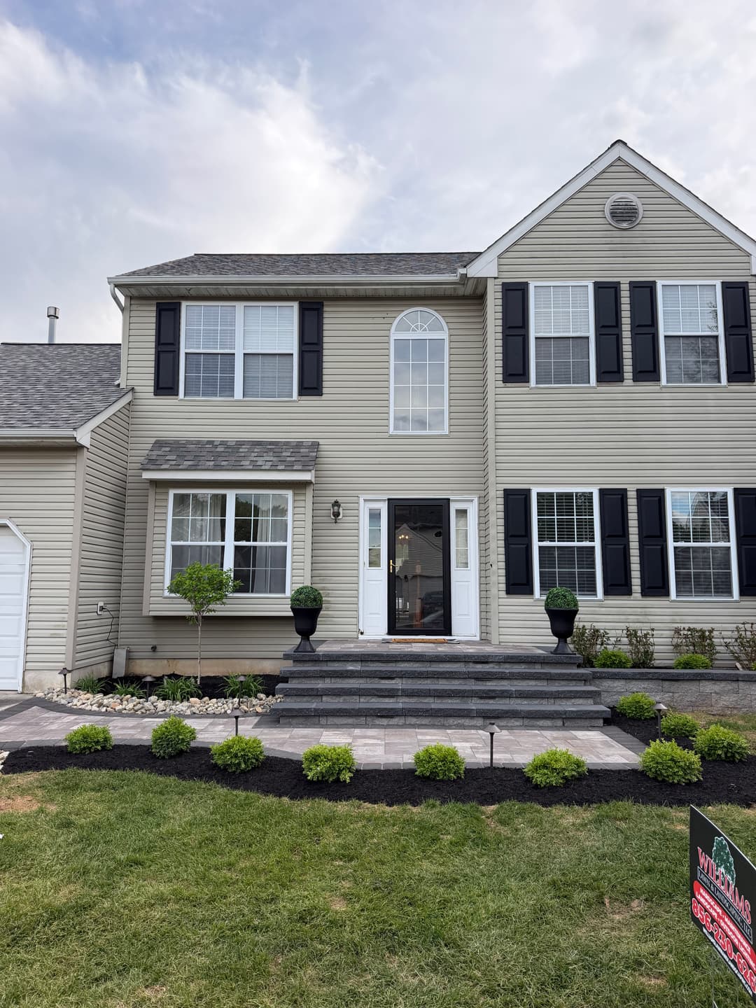 Modern two-story house with landscaped front yard and welcoming entrance.